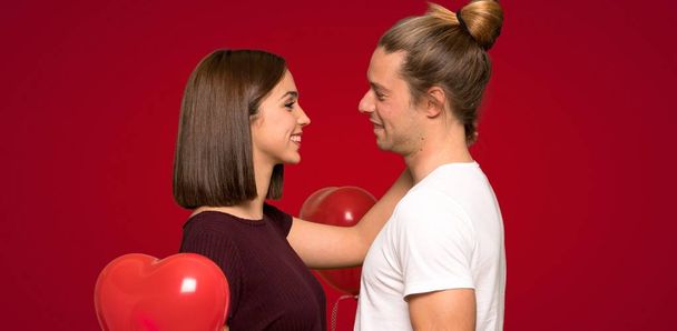 Couple dans la Saint-Valentin avec une expression heureuse sur fond rouge
 - Photo, image