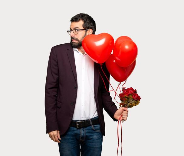 Man in valentine day is a little bit nervous and scared pressing the teeth over isolated grey background - Fotografie, Obrázek