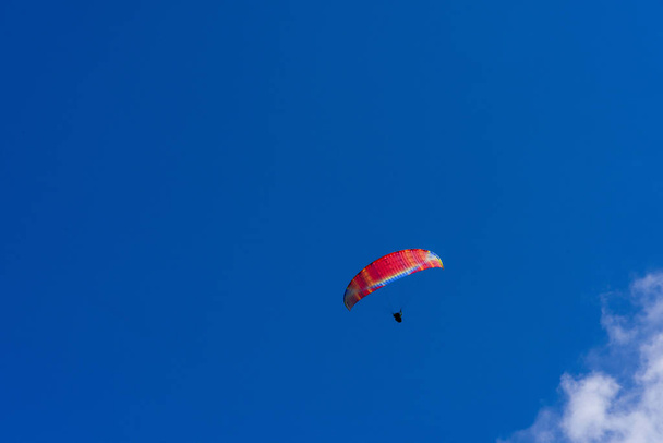 Paragliding extreme Sport with blue Sky and clouds on background Healthy Lifestyle and Freedom concept - Фото, изображение