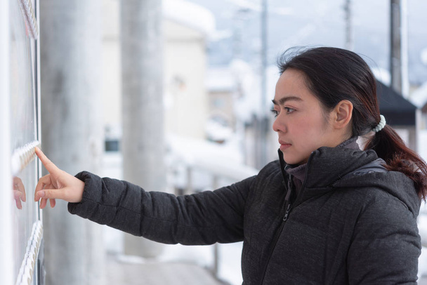 Asiatico donna viaggiatore scegliere prodotto da distributore automatico in inverno Giappone
. - Foto, immagini