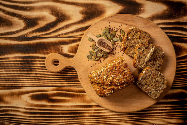 Volkoren brood met zaden van goji bes, pompoen, vlas en hennep, ruimte voor tekst. bovenaanzicht. - Foto, afbeelding