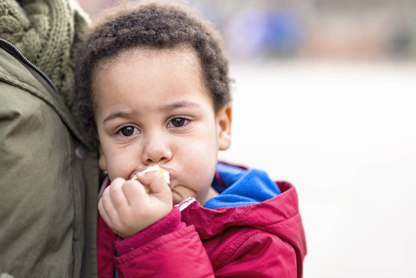 portrait d'un garçon bouleversé dans les bras de sa mère, les larmes aux yeux, mangeant de la pomme pour le confort
 - Photo, image