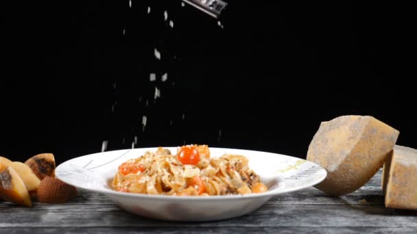 Koch reibt Hartkäse. Kochen von Meeresfrüchten Pasta. Zeitlupe eines Kochreibekäses, typisch italienischer Käse, Pasta auf Teller, frisch gekochtes Konzept: italienische Küche, Käse, Restaurant und Lebensmittel - Filmmaterial, Video