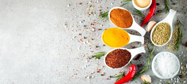 Spices in Wooden spoon. Herbs. Curry, Saffron, turmeric, rosemary, cinnamon, garlic, pepper, anise on wooden rustic background. Collection of spices and herbs. Salt, paprika. Copy space. Top view. Banner. Flat lay. - Photo, Image