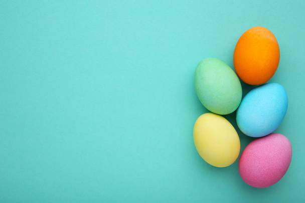Colorful easter eggs on a mint background, flat lay - Fotó, kép