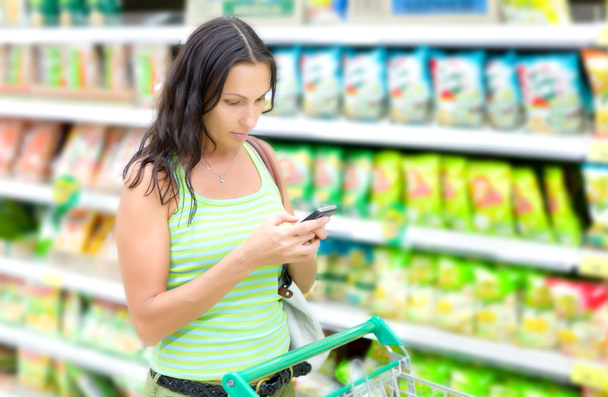Frau liest SMS in Supermärkten - Foto, Bild