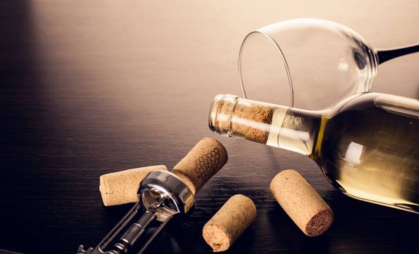 bottle of wine and corkscrew on wooden background - Photo, image