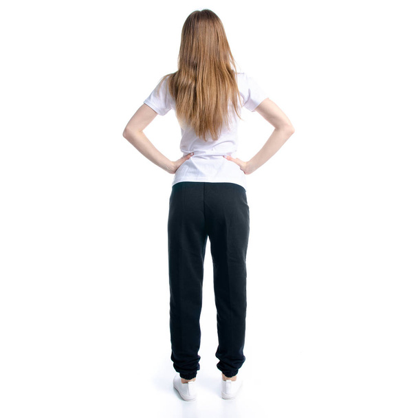 Woman in black sweatpants and white t-shirt standing - Фото, изображение