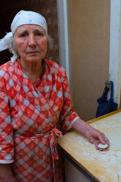 Grandmother cooks dumplings on kitchen - Foto, immagini