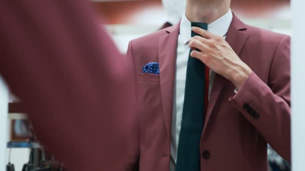 Muž oblečený v elegantním červeném obleku si vybírá kravatu - Záběry, video