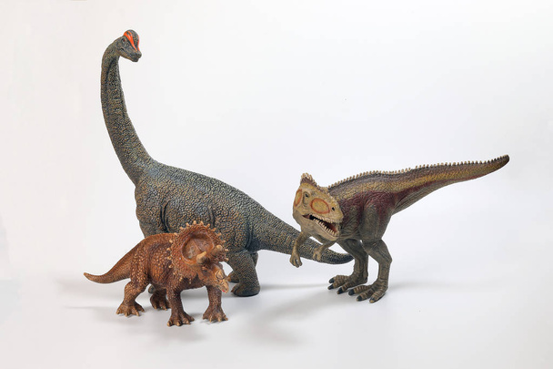 Tyrannosaurus Triceratops Brachiosaurus dinozor oyuncak heykelcik beyaz arka plan üzerinde - Fotoğraf, Görsel