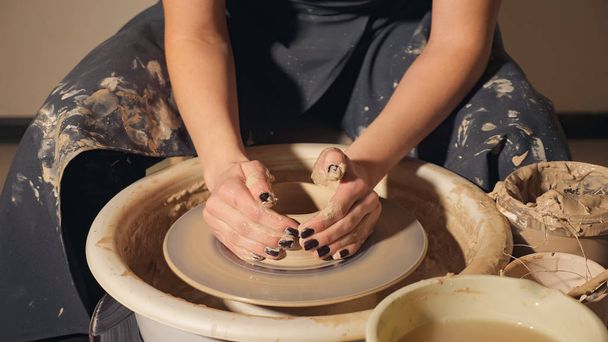the girl makes a pot of clay on a potters wheel. hands closeup - Photo, Image