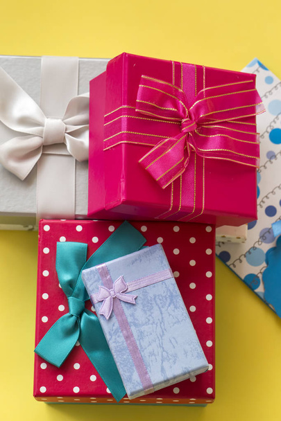 Színes ajándék meglepetés csomag, rózsaszín háttér. - Fotó, kép