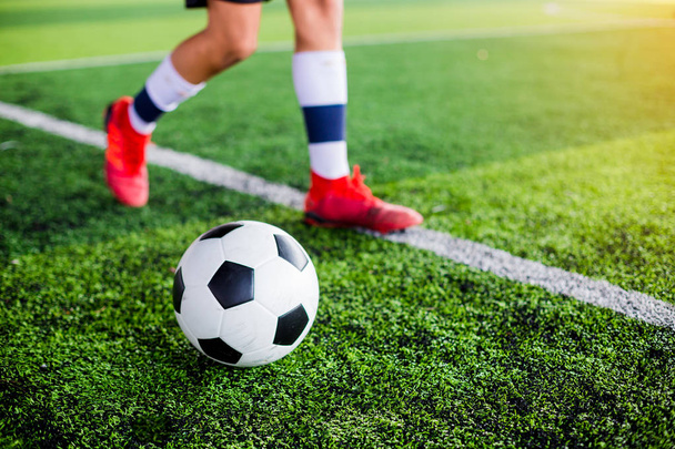 人工芝にゴールにボールをシュートするサッカー プレーヤーの速度を実行します。サッカー選手のトレーニングやサッカーの試合. - 写真・画像