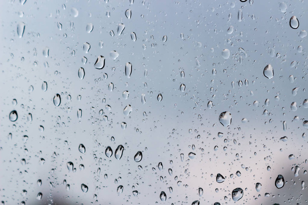 Chuva cai no vidro da janela, céu tempestuoso fora
 - Foto, Imagem