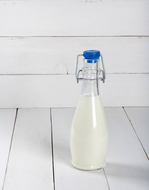 Old  vintage style bottles with fresh milk on grunge white wooden table - 写真・画像