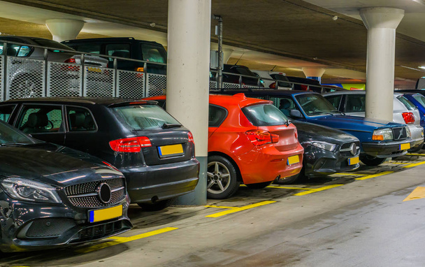 samochody zaparkowane na krytym parkingu, długi rząd samochodów, parking dla samochodów osobowych - Zdjęcie, obraz
