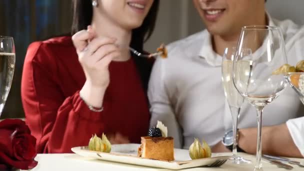 Assuntos românticos e amorosos. Casal jovem num encontro. Uma mulher alimenta o seu homem com uma deliciosa sobremesa. Um casal a rir num restaurante. Copos de champanhe na mesa. hd
 - Filmagem, Vídeo