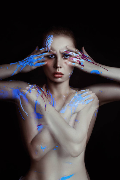 Portrait woman in drops of color paint on black background. Art Paint on the girl face and hands, fashion beauty and makeup. Double exposure overlay, no focus. Mysterious portrait splashes blue paint - Φωτογραφία, εικόνα