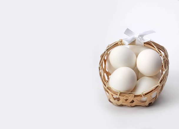 egg in basket on light gray background - Zdjęcie, obraz