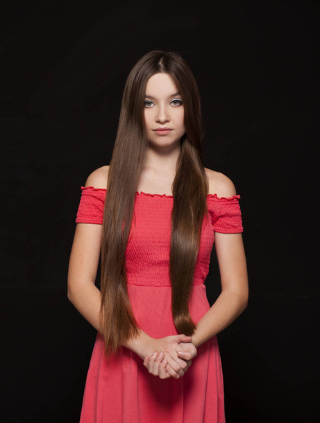 Close up Make up fashion model. Young beautiful brunette girl in red dress, on studio black wall background - Foto, imagen