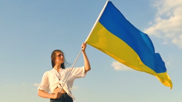 Serious girl teenager stand with Ukrainian  flag .Slow motion - Footage, Video