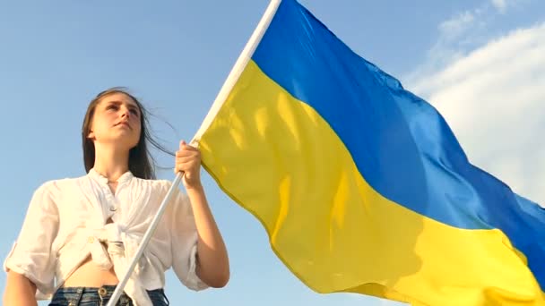 Chica adolescente de pie con bandera de Ucrania, mirar hacia adelante. Cara grave.Cámara lenta
 - Imágenes, Vídeo