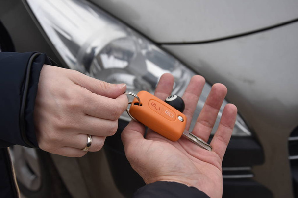 Autoverkäufe. eine Person verkauft Auto und gibt dem neuen Besitzer den Schlüssel - Bild - Foto, Bild