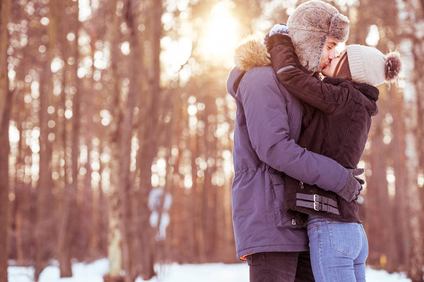 Una giovane coppia passeggia nella foresta durante l'inverno. Bel paesaggio per una passeggiata romantica
 - Foto, immagini