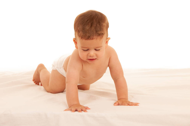 Hapy baby boy in playing on bed isolated over white - Φωτογραφία, εικόνα