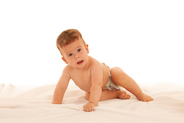 Hapy baby boy in playing on bed isolated over white - Foto, Imagem