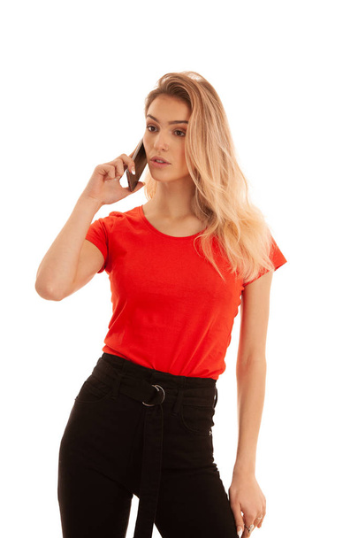 Beautiful young woman in red t shirt speak on a smart phone isolated over white background - phone chat - Foto, immagini