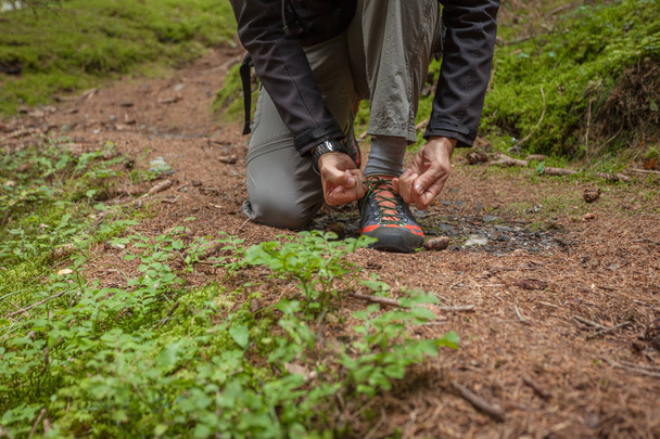 fastening your mountain shoes inside a forest - Photo, Image