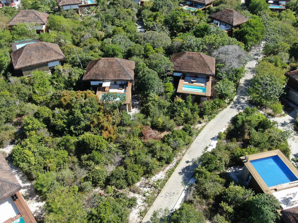Aerial view of luxury villa with swimming pool in tropical forest. Private tropical villa with swimming pool among tropical garden with palm trees next to the coast. Praia de Forte, Bahia, Brazil - Photo, Image