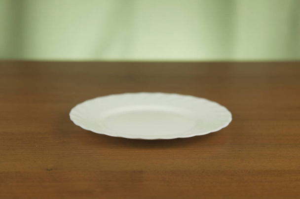 Placa vacía blanca sobre mesa de madera
 - Foto, Imagen
