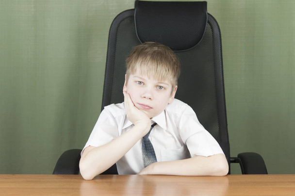 Elegáns üzleti gyermek ül a munkahelyen portréja. Aranyos kaukázusi fiú imitáló üzletember vagy hivatal munkás - Fotó, kép