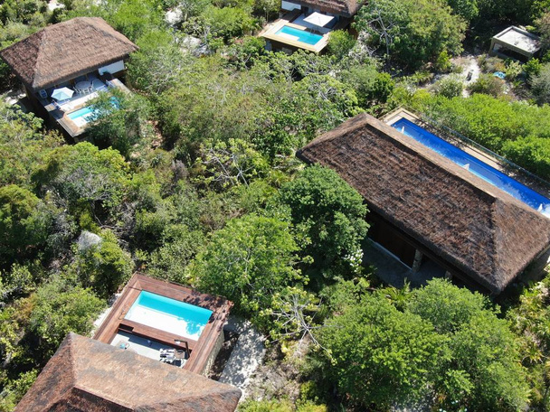 Aerial view of luxury villa with swimming pool in tropical forest. Private tropical villa with swimming pool among tropical garden with palm trees next to the coast. Praia de Forte, Bahia, Brazil - Photo, Image