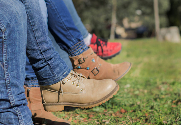 Женщина скрестила ноги с ковбойскими штанами и сапогами в поле
 - Фото, изображение