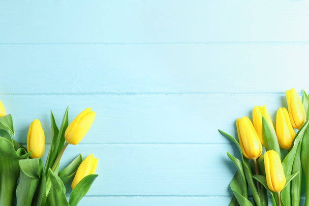 Beautiful fresh yellow tulips on wooden background, top view - Photo, Image