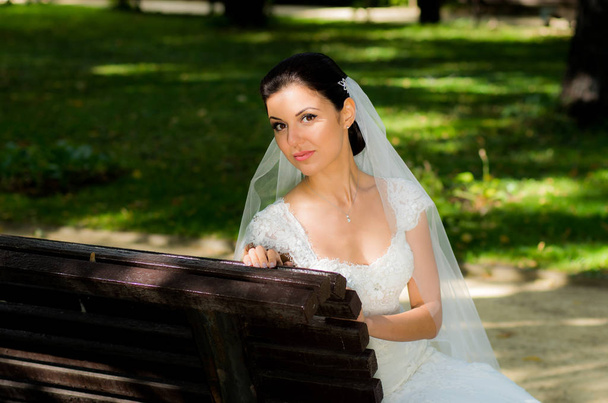 Portrait of the bride sitting on bench in the garden - Fotoğraf, Görsel