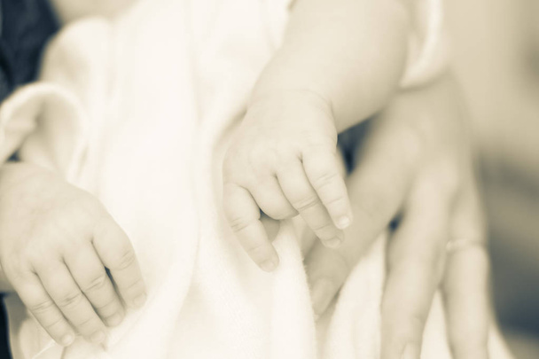 gentle touch of the hands of mothers and pens of a newborn baby. close-up. Blur - Zdjęcie, obraz