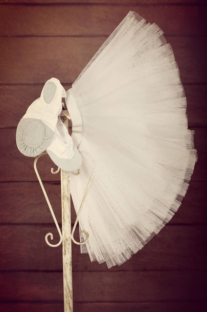 Pointes female ballet shoes with skirt tutu hanging on the stand, close up vintage vie - Фото, зображення