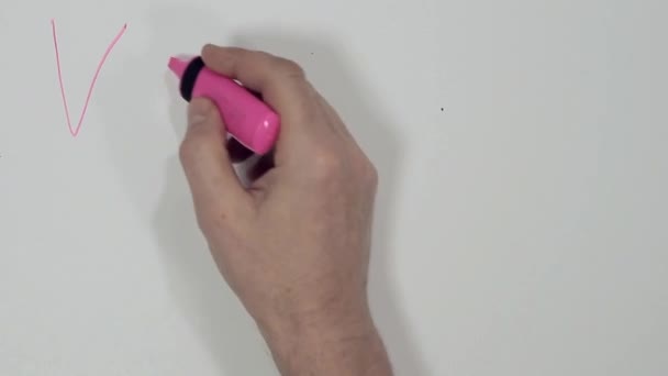 mannenhand met een roze marker schrijft de inscriptie "Valentine's Day" op een witte achtergrond en trekt een hart - Video