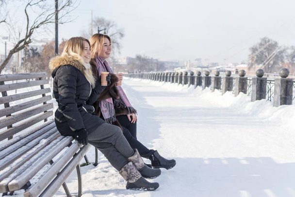 Laughing girlfriends on the bench - Zdjęcie, obraz