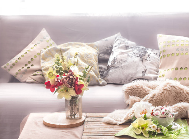 Homely confortable intérieur de printemps dans le salon avec un vase et des fleurs, concept de confort à la maison
 - Photo, image