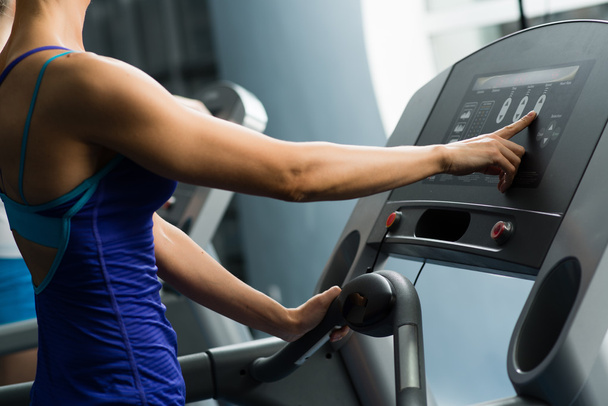 woman adjusts the treadmill - Foto, immagini