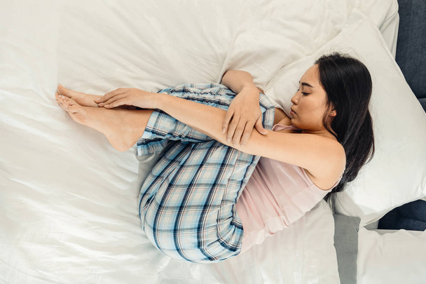Asian kobieta czuje się przygnębiony i samotny, leżąc w łóżku - Zdjęcie, obraz