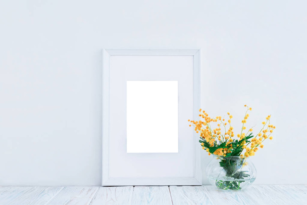 Empty white wooden frame and yellow mimosa flowers with copy space. Mockup. - Fotografie, Obrázek
