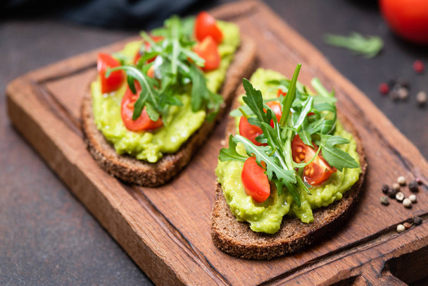 Healthy toast with avocado, tomato, arugula - Photo, image