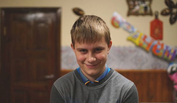 Porträt eines lustigen blonden Jungen, der gleichzeitig lächelt und runzelt die Stirn - Foto, Bild